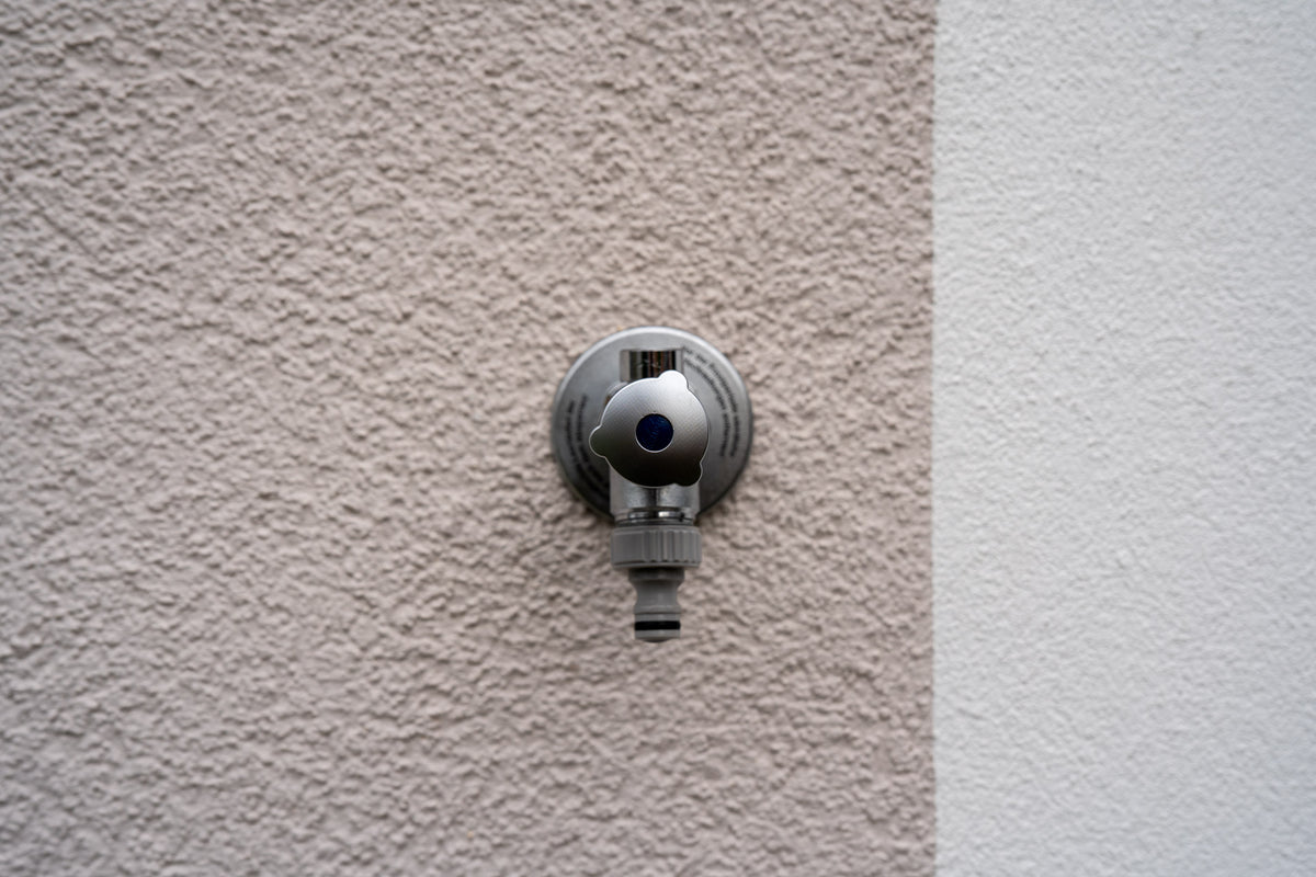 Makellose WDVS-Fassade mit frostsicherer Außenwasserhahn: Werterhalt der Dämmung durch den bohrfreien Gardenicer Schlauchhalter.